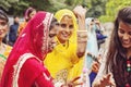 Young Indian girls in traditional sari, dancing at wedding crowd on the street