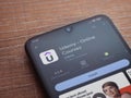 Udemy app play store page on smartphone on wooden background