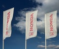Honda banners outside the dealership of the area against blue sky with clouds. It is the symbol of the japanese car manufacturer Royalty Free Stock Photo