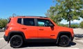 Jeep Renegade orange edition parked at the road side. Side view