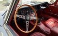 Wooden steering wheel and black dashboard of Jaguar E-Type , british sports car from Sixties.