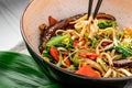 Udon stir fry noodles with beef meat and vegetables in a plate on white wooden background Royalty Free Stock Photo