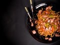 Udon stir fry noodles with chicken in black plate on a dark background Royalty Free Stock Photo