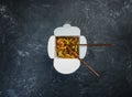 Udon stir fry noodles with chicken in a box on a vintage colored background. Top view. With chopsticks
