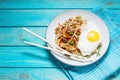 Udon stir-fry noodles with chicken on wooden background