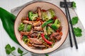 Udon stir fry noodles with pork meat and vegetables in a plate on white wooden background Royalty Free Stock Photo