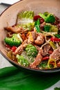 Udon stir fry noodles with pork meat and vegetables in a plate on white wooden background Royalty Free Stock Photo