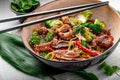 Udon stir fry noodles with pork meat and vegetables in a plate on white wooden background Royalty Free Stock Photo