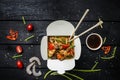 Udon stir fry noodles with seafood in a box on black background. With chopsticks and sauce. Royalty Free Stock Photo