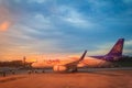 Thai Smile airline parking at the terminal during sunset at Udon Thani International Airport (UTH) in the northeast region of Thai