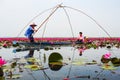 Fisherwoman on blue boat fishing by using fishing traditional fishing net