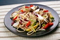 Udon wok noodles with pork and peppers, served on black plate, c Royalty Free Stock Photo