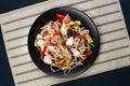 Udon wok noodles with pork and peppers, served on black plate, f Royalty Free Stock Photo