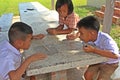 Three Asian children are playing together in lunch-break.