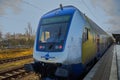 Railcar of the Metronom regional train stands on the tracks at the platform edge of the station