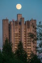 Uenusually large moon over the skyscraper in a summer evening sky. Royalty Free Stock Photo