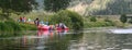 Ufa / Russia - July 16 2017: Boats on the lake. Group of people standing near canoes and kayaks on a green grass near river.