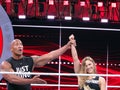 UFC star and Bantamweight Champion Ronda Rousey and the Rock celebrate by raising arms in the ring
