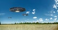 UFO, an alien plate hovering over the field, hovering motionless in the air. Unidentified flying object, alien invasion, Royalty Free Stock Photo