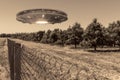 UFO, an alien plate hovering over the field, hovering motionless in the air. Unidentified flying object, alien invasion, Royalty Free Stock Photo