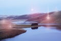 UFO concept. Glowing orbs, floating above a bleak, moody mountain and reservoir landscape. On a winters evening