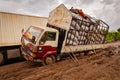 Accident scene of a large semi trucks stuck in the muddy, rutted, unpaved road