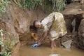 Ugandan Girl cleaning thongs in well