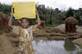 Ugandan Girl at well carrying drinking water