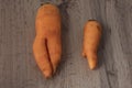 Ugly fresh carrots on woprktop. In the background is a carrot cake. horizontal orientation Royalty Free Stock Photo