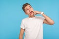 Ugly habit. Portrait of foolish uncultured man in casual white t-shirt pulling out boogers, picking dirty nose Royalty Free Stock Photo