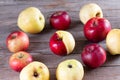 Ugly, juicy apples with defects on the skin on the wooden background. Funny, strange, imperfect fruits. Food waste and ugly food