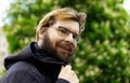 Ugly middle adult man portrait smiling face with mustaches and beard, looking at camera with glasses, outdoor park Royalty Free Stock Photo