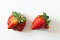 Ugly organic home grown strawberries on white wood background. Strange funny imperfect fruits and vegetables, misshapen produce, f