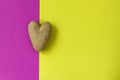 Ugly potatoes in the form of a heart on a double background green and pink. Funny, unusual concept of vegetables or food waste.