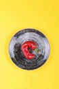 Ugly red chili peppers on a black plate on a yellow background, minimal style of nature, pop art, creative food concept, modern