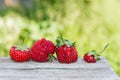 Ugly strawberries lie on an old wooden table outdoors. Latest trend - Eating imperfect fruits, reducing food waste