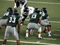 UH Football and UC Davis players standing squating ready for play during college game Royalty Free Stock Photo