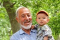 UHUM, UZBEKISTAN - MAY 16, 2011: Portrait of an old Uzbek man with his grandson in Uhum village Royalty Free Stock Photo