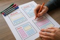 UI designer coloring website header and menu wireframes with markers UI design user interface Royalty Free Stock Photo