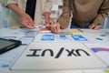 UI UX Design Session. Team members collaborating on mobile app wireframes. Royalty Free Stock Photo