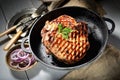 Uicy steak with parsley in a frying pan, onions, vintage knife and fork, a napkin on a gray background Royalty Free Stock Photo