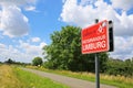 Red sign with message welcome to bicycle paradise limburg at cycling path in rural landscape of river Maas valley Royalty Free Stock Photo