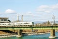 Closeup white train is crossing a river by the bridge under bright blue sky Royalty Free Stock Photo