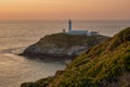 UK, Anglsey - Sept 202: Sun setting behind the famous South stack lighthouse Royalty Free Stock Photo