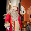 UK, Belfast - Dec 2012: Traditional Father Christmas character outside a brightly lit chritmas house