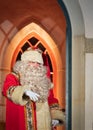 UK, Belfast - Dec 2012: Traditional Father Christmas character outside a brightly lit chritmas house