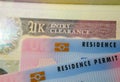 UK BRP Biometrical Residence Permit cards for Tier 2 work visa placed on top of United Kingdom Entry Clearance vignette sticker