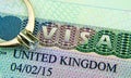 UK entry visa sticker in a passport and the engagement ring placed on top. Conceptual photo for fiance / spouse visa and