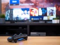 UK, Jan 2020: Sony dualshock 4 controller remote for Playstation 4 with tv screen behind