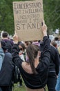 UK, London, 3/6/2020 - A brunette caucasian female holding up an anti-racism banner in Hyde Park, London at the Black Lives Matter